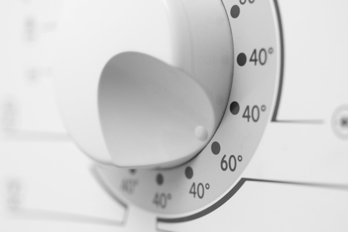 Punaises de lit : À quelle température faut-il laver pour tuer les punaises ? Illustration montrant machine à laver avec thermomètre indiquant 60°C et textiles traités.